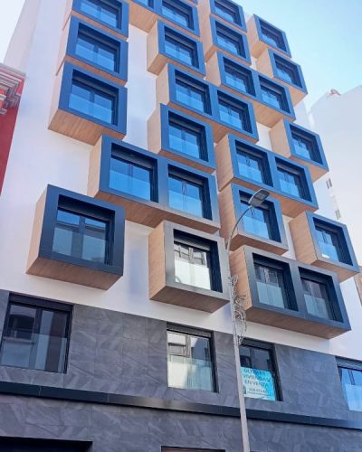 Fachada Edificio Juan Manuel Durán Las Palmas, revestimiento en blanco con ventanas en cajones madera y negro