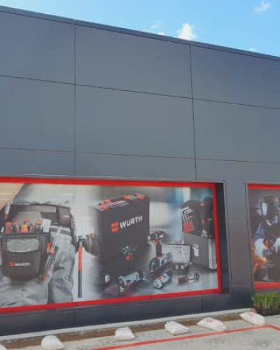 Fachada Nave Würth, revestimiento en negro y entrada a la tienda en rojo