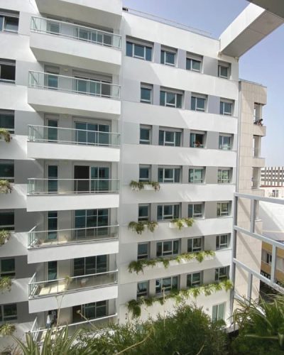 Fachada Residencial Castillejos 95 Las Palmas, revestimiento en blanco y carpintería en color plata